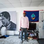 A student poses in his dorm room.