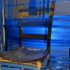 A photo detail of a sculpture made from blue table and a wooden chair.