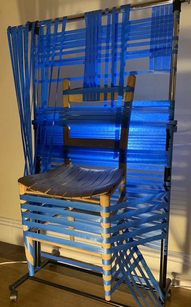 A photo of a sculpture made from blue table and a wooden chair.