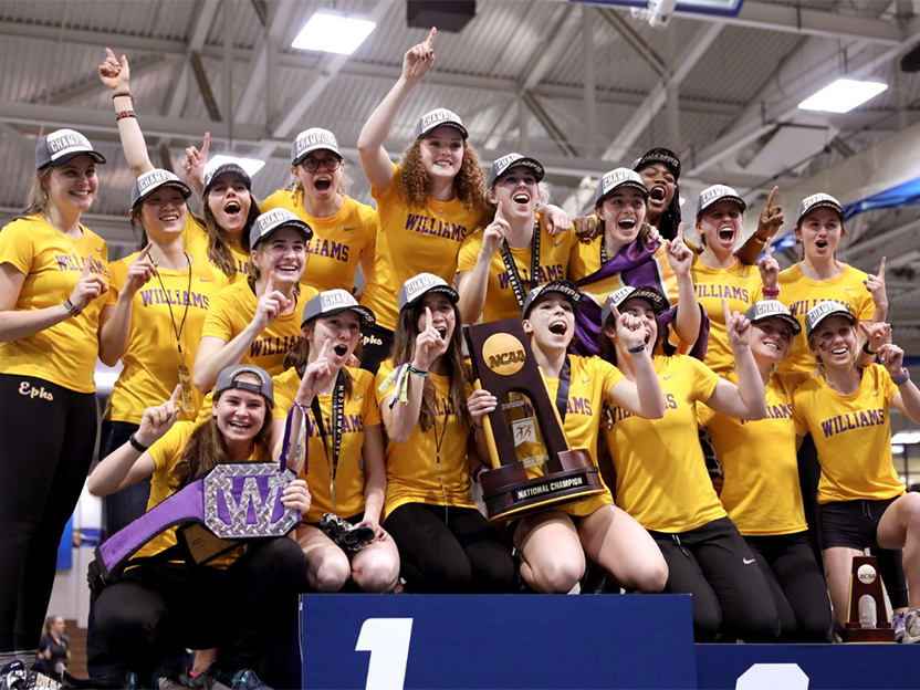 Women's track team posing for a photo with trophy.