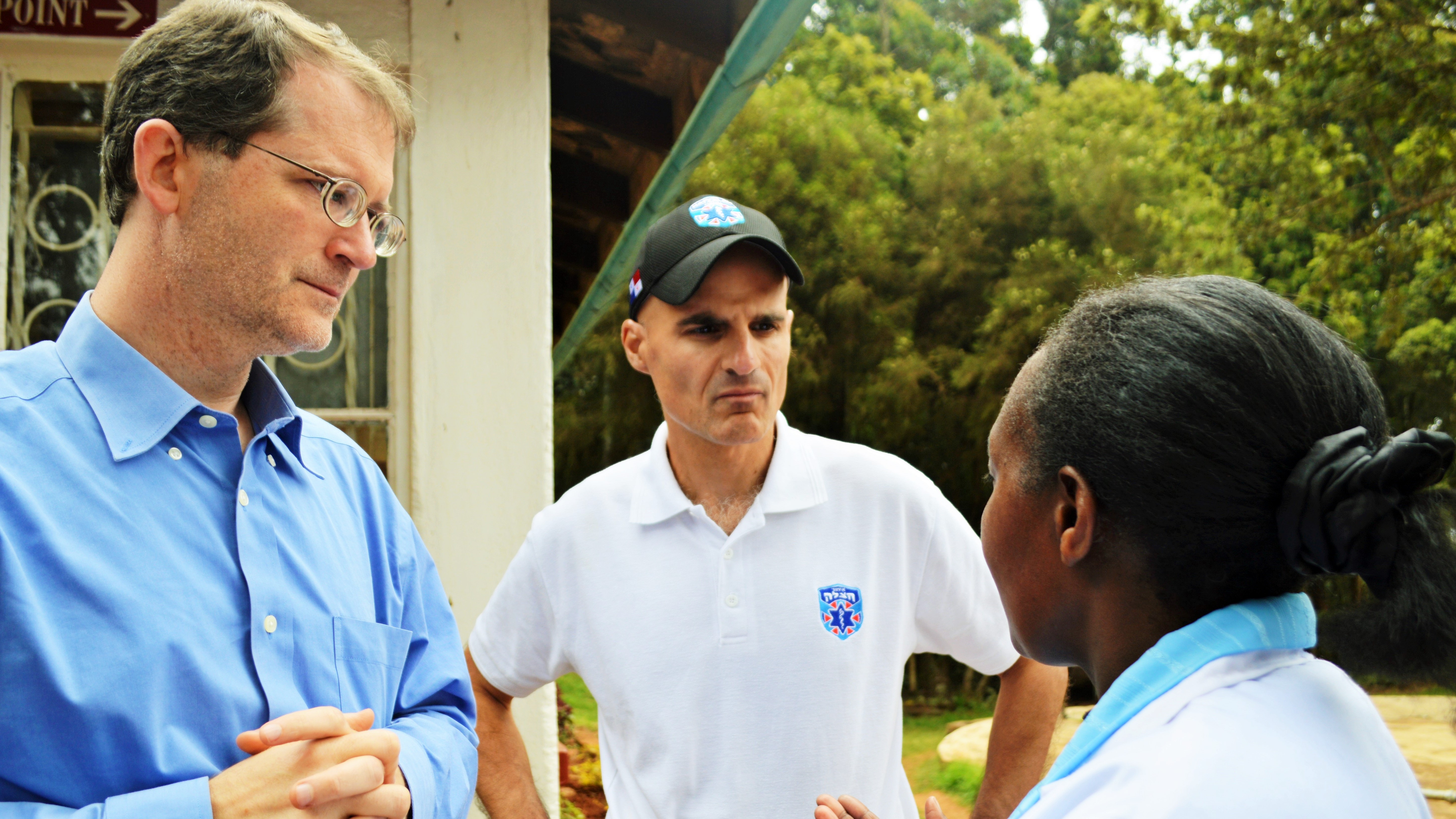 Jon Fielder ’94 (left) and Mark Gerson ’94 (center) speak with a community worker.