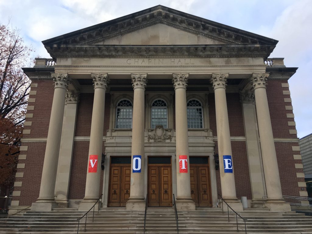 Chapin Hall at Williams College is seen from the front and its columns are decorated with banners spelling out V-O-T-E.