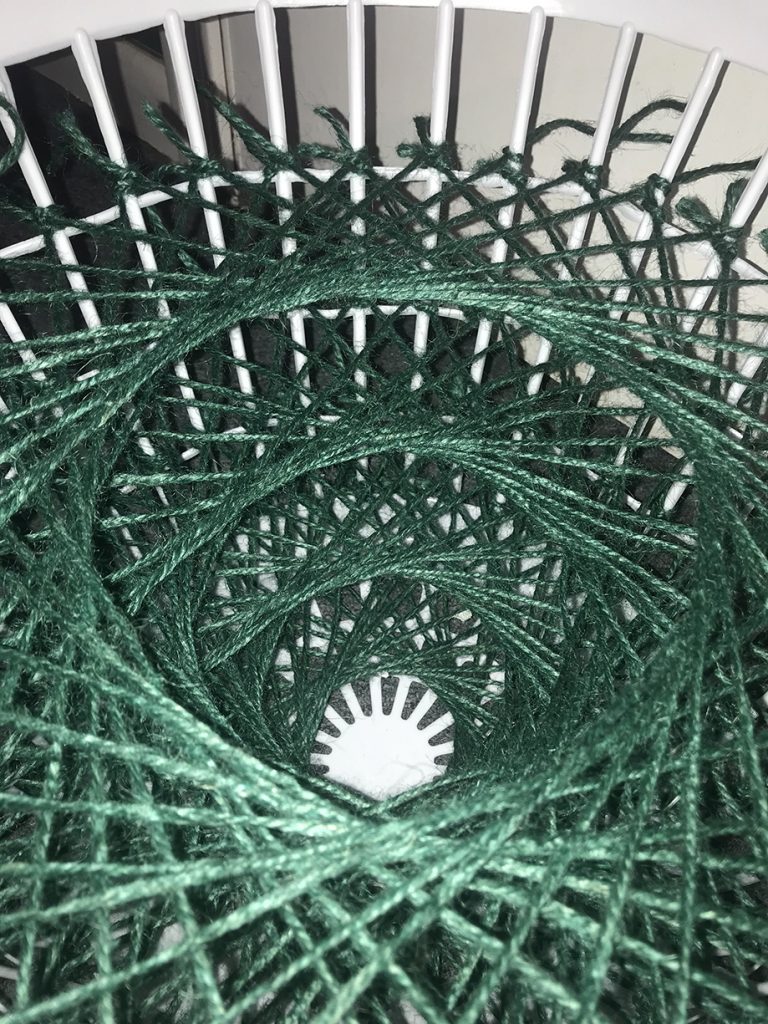 A portrait of a sculpture made with string and a basket