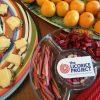 Photograph of the Licorice Project logo on a plate of licorice, accompanied by hors d'oeuvres.