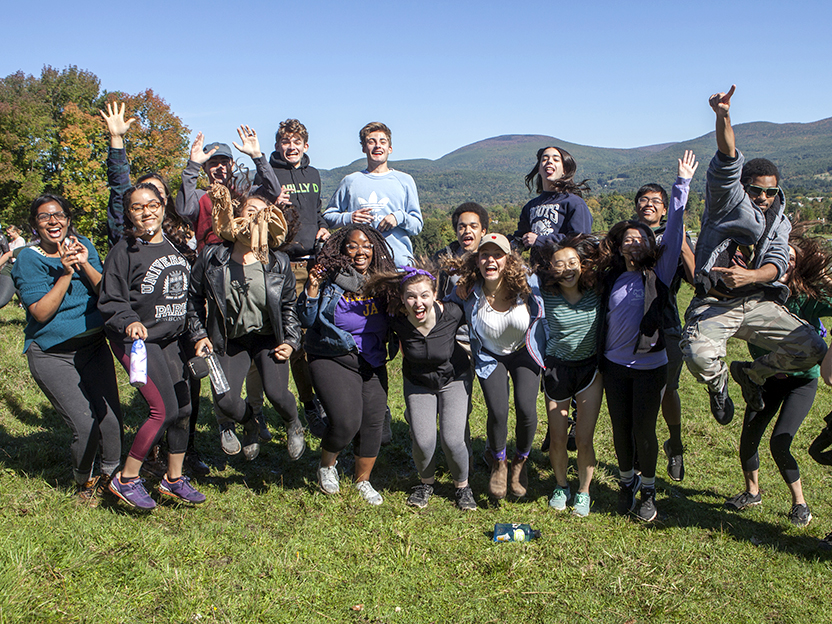 Students leaping into the air with mountains in the background