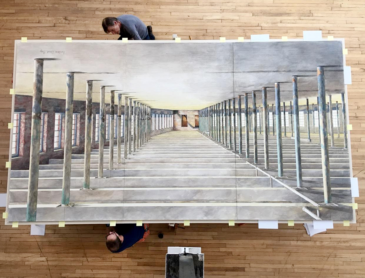 A photograph of workers preparing an oversized water color of the interior of Building 6, the latest expansion of the Massachusetts Museum of Contemporary Art. The water color was painted by Barbara Ernst Prey, Williams Class of 1979.