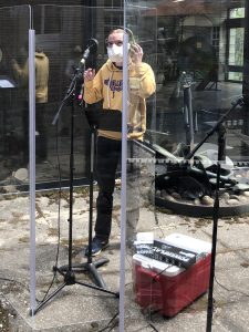 Student singing in an outdoor recording studio.