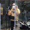 Student singing in an outdoor recording booth.