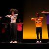 A group of men and women perform a step routine on stage.