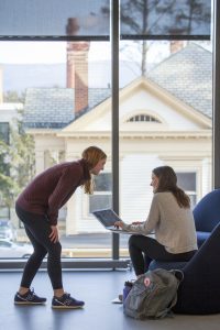 Picture of two students working together with a laptop computer