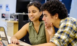 Two students studying at a laptop